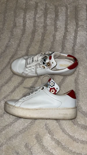 Michael Kors skor - Säljer mina Michael Kors skor då de blivit för små. De är rätt så använda, men inga skador, bara lite missfärgningar på sulan. Dem har fina blommor och guld detaljer. 