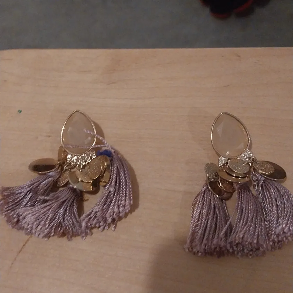 Ett kit med 2 par örhängen, ett par lila och ett par svarta örhängen som är oanvända. . Accessoarer.