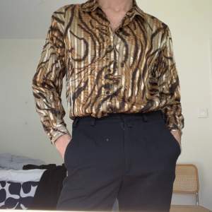 En tigerrandig skjorta från ”Okief&Okief”. See through med spår av glittrigt guld!