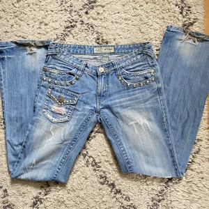 Lågmidjade, utsvängda jeans. - Superfina, kommer inte till användning längre. Midjemått: 40 cm tvärs över. Innerbenslängd: 85 cm. Benvidd: 23 cm.