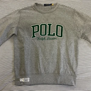 Ralph Lauren Sweater - Helt ny Polo Ralph Lauren sweater i förgen grå.  Storlek M.  Lappen sitter kvar så tröjan är helt oanvänd. Jag är 185 cm lång och passformen är normal. 