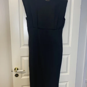 Figur sydd klänning  - Svart elegant figursydd klänning i storleken L men passar även M. Helt ny 