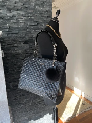 Steve Madden Tote - Supersnygg rymlig SM Tote, svart med silverdetaljer mått ca: 32x30x12 cm. Väskan är i nyskick. Skickar fler bilder vid intresse. Hämtas på plats eller skickas mot fraktkostnad. 