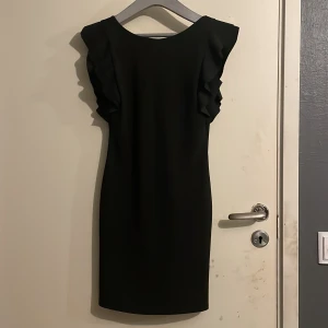 Svart cocktail klänning  - Svart cocktail klänning med djup rygg. Använd fåtal gånger. Storlek S men stretchig så kan passa en S/M också. 
