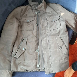 Jacka J.Lindeberg - Brun jacka i gott skick. Saknar en knapp i mitten som bilden antyder