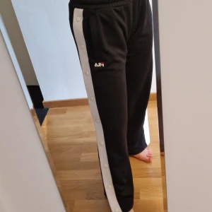 Fila Knappbyxor  - Super snygga fila byxor med knäppning längs hela benen. Med fickor och snöre insidan vid midjan som kan knytas. Stl xs