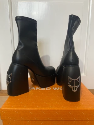 Naked Wolfe Klackskor - Naked Wolfe Spice Black Stretch Klackskor. Köpt för 3700kr  Använda bara 1 gång, säljer för att jag slutat använda klackskor.  Original låda tillkommer. Skorna är stretchiga och lätta trots klackens storlek. Klacken är 13cm och platån där fram 5,7cm.