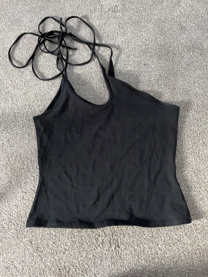 Linne Weekday - Linne från Weekdag Michell oneshoulder tank i svart. Bild två är en produktbilder av linnet men i en annan färg. 