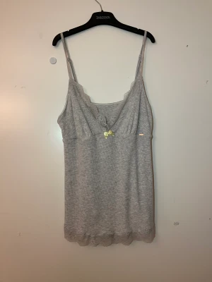 Grått linne med rosett  - Gullig grå tops med spets! Storlek s/m, endast använd en gång. 