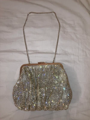Glitter väska, ZARA - Axelremväska, strass guld från ZARA. Höjd 18 cm, bredd 21 cm. Helt oanvänd! Köparen står för frakt.  