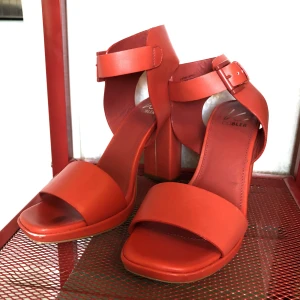 Röda högklackar K. Cobler - Läckra röda nästan oanvända klackar i stl 38 från märket K. Cobler. Bekväma och lätta att gå i men tyvärr har jag en stl mindre. Klacken och även innersulan på skon är av skinn, yttersula av gummi. Nypris 999kr.