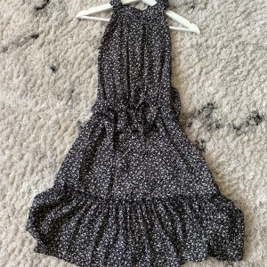 Ny sommar klänning  - Helt ny halterneck klänning svart med vitt mönster, knyt band i midjan