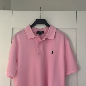 Ralph Lauren Piké  - Tja, säljer nu denna snygga Ralph Lauren Piké. Den är som ny 9/10 skick. Mycket fin färg nu till sommaren! Skulle säga att den sitter som M/S. Hör av dig vid frågor eller funderingar! 