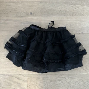 Svart puffig kjol dollskill - Puffig svart kjol med rosett och justerbar midja