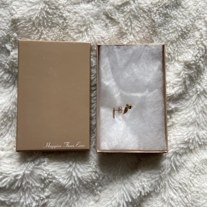 BILLIE EILISH ÖRHÄNGEN - ÄKTA GULD <3 - Jag säljer dessa oanvända örhängen från Billies officiella webshop i äkta guld. Inköpta för 400kr, men inklusive frakt och tull kostnader på ca 250kr är detta priset billigare. <3 Samt att frakten tar 3 månader. Skickar även med två Billie bilder! 