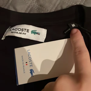 Lacoste t shirt - En oanvänd lacoste t shirt, aldrig använt då det är fel storlek och har aldrig tänkt på att sälja. Priset inte hugget.