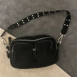 Handväska - En handväska i fint skick med fyra fack + ett litet innerfack. Ca 25 cm lång