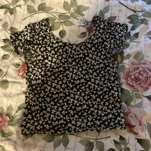 Topp - En svart topp med små blommor. Använt några gånger. 