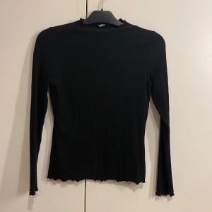 Långärmad tröja - En svart ribbad långärmad tröja. Använd fåtal gånger 