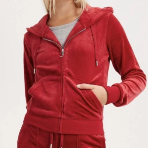 Juicy Couture - Säljer min helt nya Juicy Couture robertson hoodie i färgen röd. Beställde två men den andra satt bättre och kunde ej lämna tillbaka denna pga sömmen som gått upp på vänstra fickan, går att fixa som ny genom att sy. Använd en gång. Köpt för 1299kr.