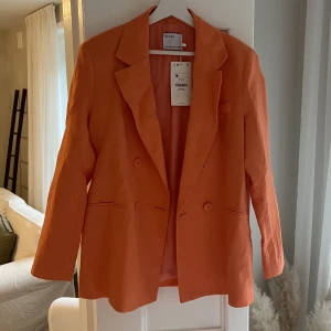 Orange kavaj  - Helt oanvänd kavaj ifrån Berskha i en härlig orange färg. Nypris 600kr.