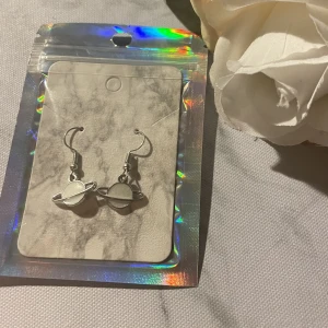 Örhängen - Silverfärgade örhängen med vita planeter! Priset är 10 kr + frakten är 15 kr med Swish och vid köp av flera smycken så samfraktar vi❤️