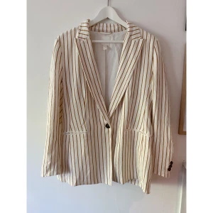 Kavaj  - Kavaj från H&M med ränder. Skulle säga att kavaj ärr off-white med ljusare brun/oranga tände på.  Väldigt fint skick. 