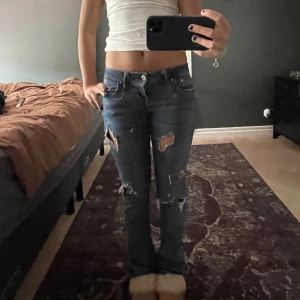 Lågmidjade jeans med hål i - Säljer dessa supersnygga lågmidjade jeans med hål ni. Dom kommer från Ltb och är modellen valerie men har klippt till hålen själv. Jag är 168 å dom sitter lpngt på mig😍
