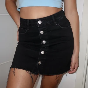 Svart kjol med knappar framme - Knappt använd 