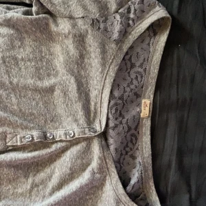 Söt topp - Från hollister. Köpt för lämge sedan. Storlek M men skulle säga att den passar som S. Spets där fram och på ryggen som bilderna visar. Grå. Skriv för mer info💞