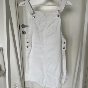Jättefin vit hängselklänning med justerbara band över axlarna och knappar på båda sidorna. Hel och ren. Passar en small eller medium om man inte har väldigt breda höfter.