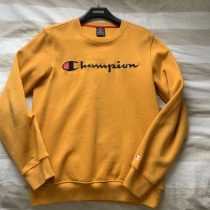 CHAMPION Tröja - En mörkgul tröja ifrån märket Champion. Passformen är normal och storleken är S