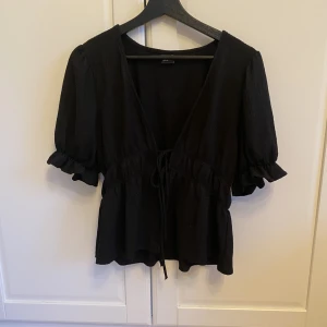 Blus  - Jättesöt blus från Gina Tricot med rosettknyte där fram och lite puffiga ärmar. Storlek M, passar S-M.