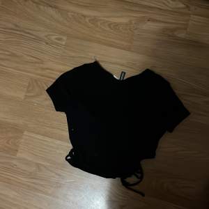 Ribbad svart t-shirt med hål på sidorna inte mycket använd och bra skick.1