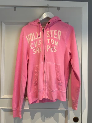 Zip hoodie - En rosa zip hoodie från hollister i storlek M. Använd flertal gånger.  Säljer för 50 kr + frakt
