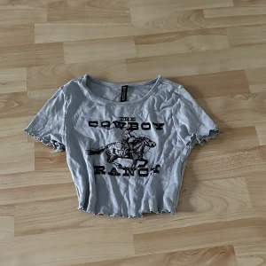 Blå crop top med svart tryck - Från H&M