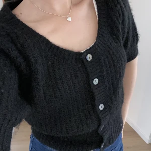 Stickad tröja Lindex  - Säljer en superfin svart stickad tröja med korta ärmar från Lindex🌱 Skick: Använd men fortfarande väldigt bra skick.  Material: 77% polyester 20% akryl 3% elastan  Storlek: xs (kan passa s)  Pris: 110 kr inkl frakt  ✨inga husdjur eller rökning 