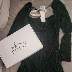 Svart pärlad festklänning Oh Polly - Svart miniklänning från Oh Polly. Aldrig använd, prislapp och skydd sitter kvar. Nypris 1035 kr från Storbritannien. Storlek UK 18, men jag som är en L/XL upplevde den som liiite stor, därför jag säljer den. Supersmickrande silhuett på en XL!