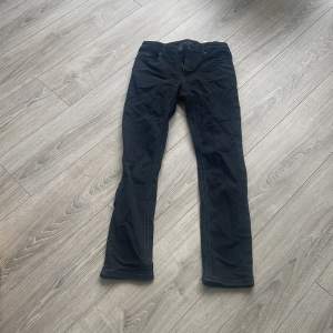 Ett par svarta jeans i märket tommyhilfiger gant