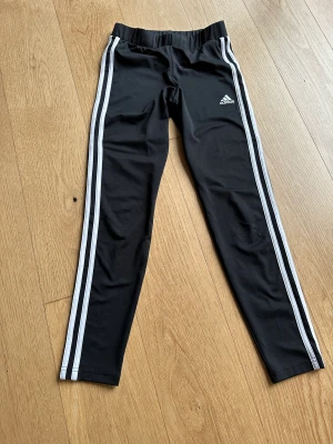Adidas träningsbyxor (11-12Y / 152) - Klassiska adidas träningsbyxor i stl 152. Endast använda ett par gånger, som nya. 