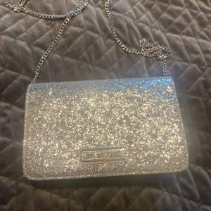 Snygg handväska i silver/ glitter med silverskedja  Bra skick- använd 1 gång 