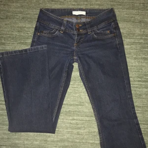 Lowwaist mörka jeans  - Ett par mörka lågmidjade utsvängda jeans som ja säljer för att gylfen är sönder och de är lite för korta för mig som är ungefär 175 cm lång. Skriv för mått och för fler bilder! 
