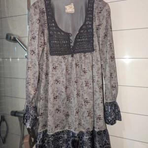 Container tunika - Väldigt fin tunika med många arbetade detaljer; spets, virkat liv och skimrande tyg. Har en S och en L till salu, tyvärr passar modellen inte mig.