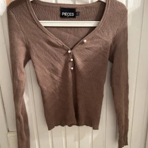 Topp - Superfin långärmad topp med gulliga knappar. 