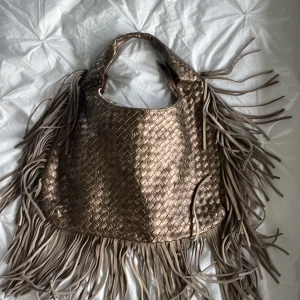 stor bronzig handväska  - säljer en ganska stor bronzig handväska som är köpt på arkivet! säljer för att den inte har kommit till användning och den är i perfekt skick!