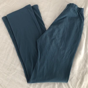 Högmidjade stretchiga byxor  - Petrolfärgade supersnygga högmidjade stretchiga byxor. Resor i midjan, utsvängda i benen. Köpta på secondhand på Bricklane i London. Lite noppriga. Skulle gissa på storlek 36. Passar mig tyvärr inte längre men förtjänar en ny ägare!💋