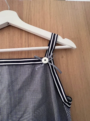 Blåvit sommarklänning - Supersöt sommarklänning i vitt och marinblått. Svalt och tunt tyg. Kort i längden. Inga skador, som ny.