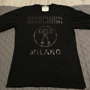 Moschino Sweatshirt  - Moschino långärmad t-shirt (är alltså tunn)  Stl M Cond 7/10, finns nån fläck vid armarna 