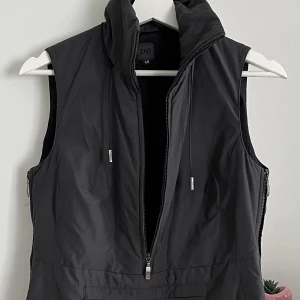 Mörkgrå väst i y2k stil - Denna väst är i sjukt bra skick trots att jag köpte den på secondhand. för några månader sen. Dragkedja finns på varje sida och på framsidan. Detta gör att man kan styla den på mpnga olika sätt. Passar både S och M  