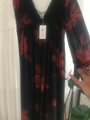Underbar långklänning med rosor & långärm🌹  - Ljuvlig långklänning passar både till fest och ”bara för” du vill var snygg en kväll ♥️👌🏾  Svart botten och fylld med röda blommor och tunna vida ärmar! Älskar denna klänning, säljer den då mina byst var lite stora 🤦🏾‍♀️ storlek M snörning bak 😍 prislappen kvar